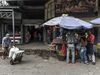 Members of the Bolivarian National Guard stand guard as shoppers browse goods at the Municipal Market of Quinta Crespo in Caracas, Venezuela.
