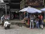 Members of the Bolivarian National Guard stand guard as shoppers browse goods at the Municipal Market of Quinta Crespo in Caracas, Venezuela.