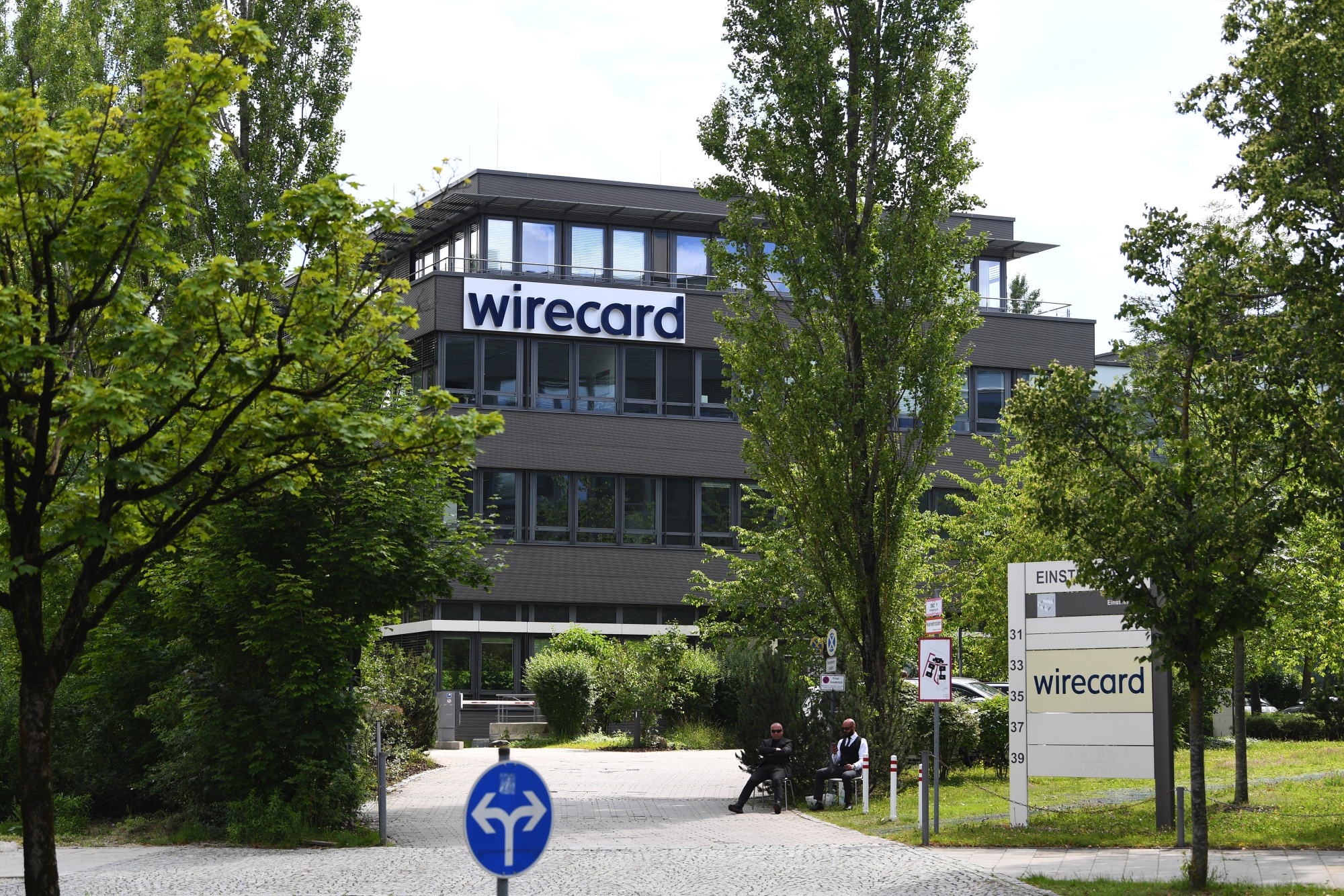 Security guards sit beside a driveway outside the Wirecard AG headquarters in Munich.