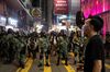 A pedestrian walks past riot police during a protest in the Causeway Bay district of Hong Kong, China, on Sunday, Sept. 8, 2019.