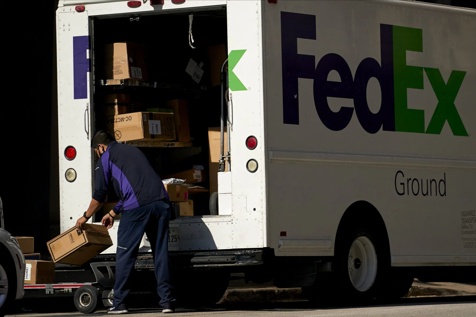A FedEx Corp. worker unloads a truck in downtown Dallas, Texas.