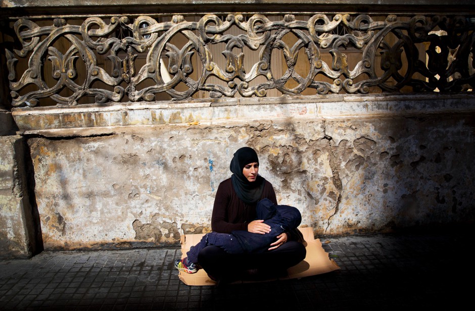 A Syrian refugee holds her child as she begs on the streets of Beirut. 