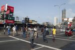 Pedestrians cross a street after a nationwide curfew was lifted for a few hours in Colombo on May 12.