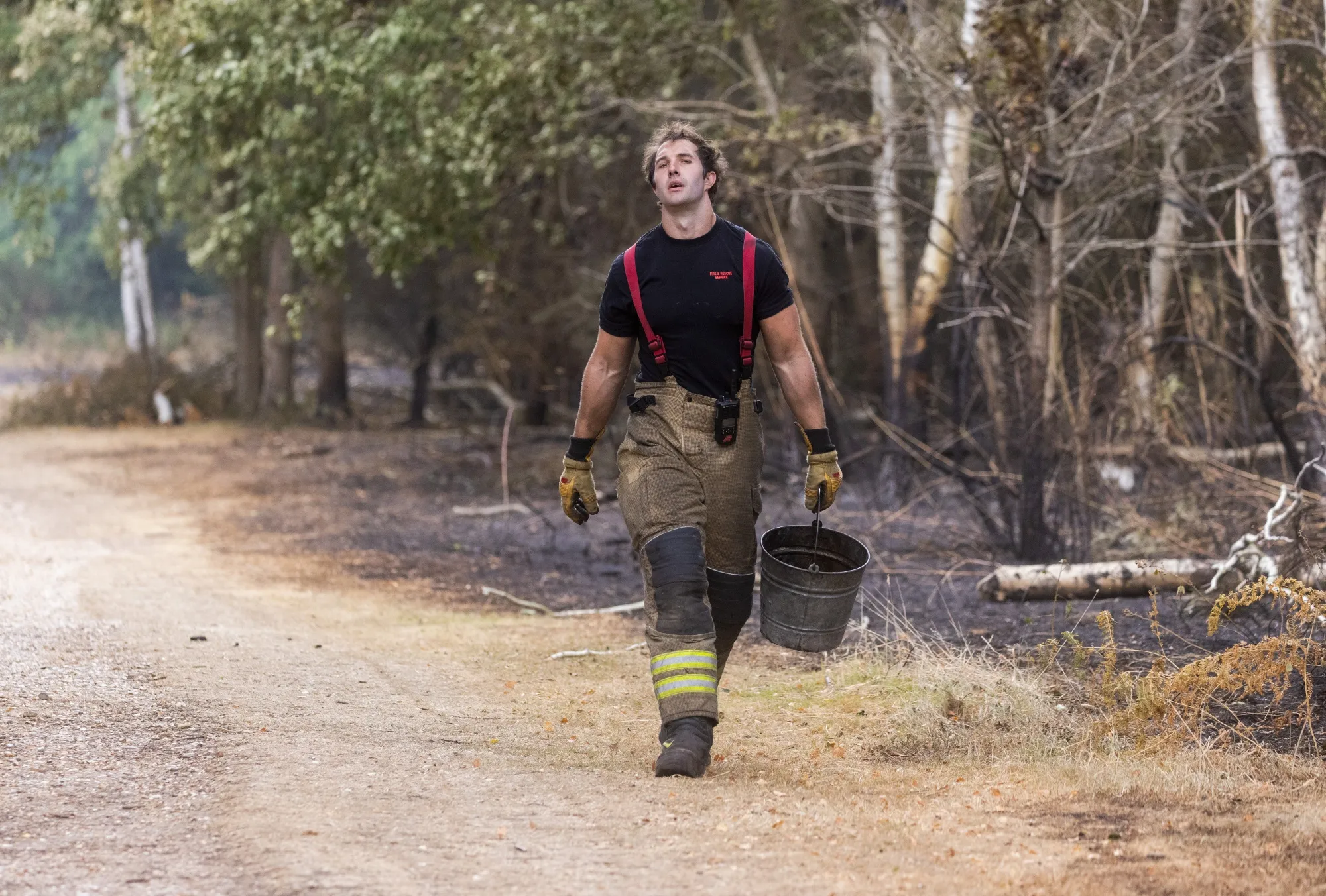 A firefighter carries a bucket of water to dampen the ground&nbsp;following a fire on Dartford Heath near Dartford, UK, on Wednesday, July 20, 2022.&nbsp;
