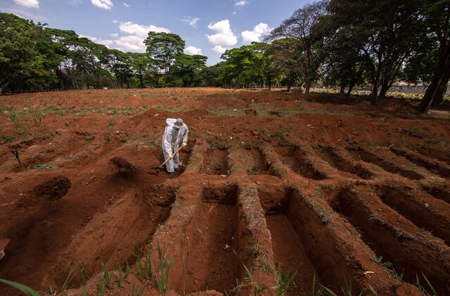 A worker wearing protective gear buries the casket of a Covid-19 victim at the Vila Formosa cemetery in Sao Paulo in Aug. 2020.