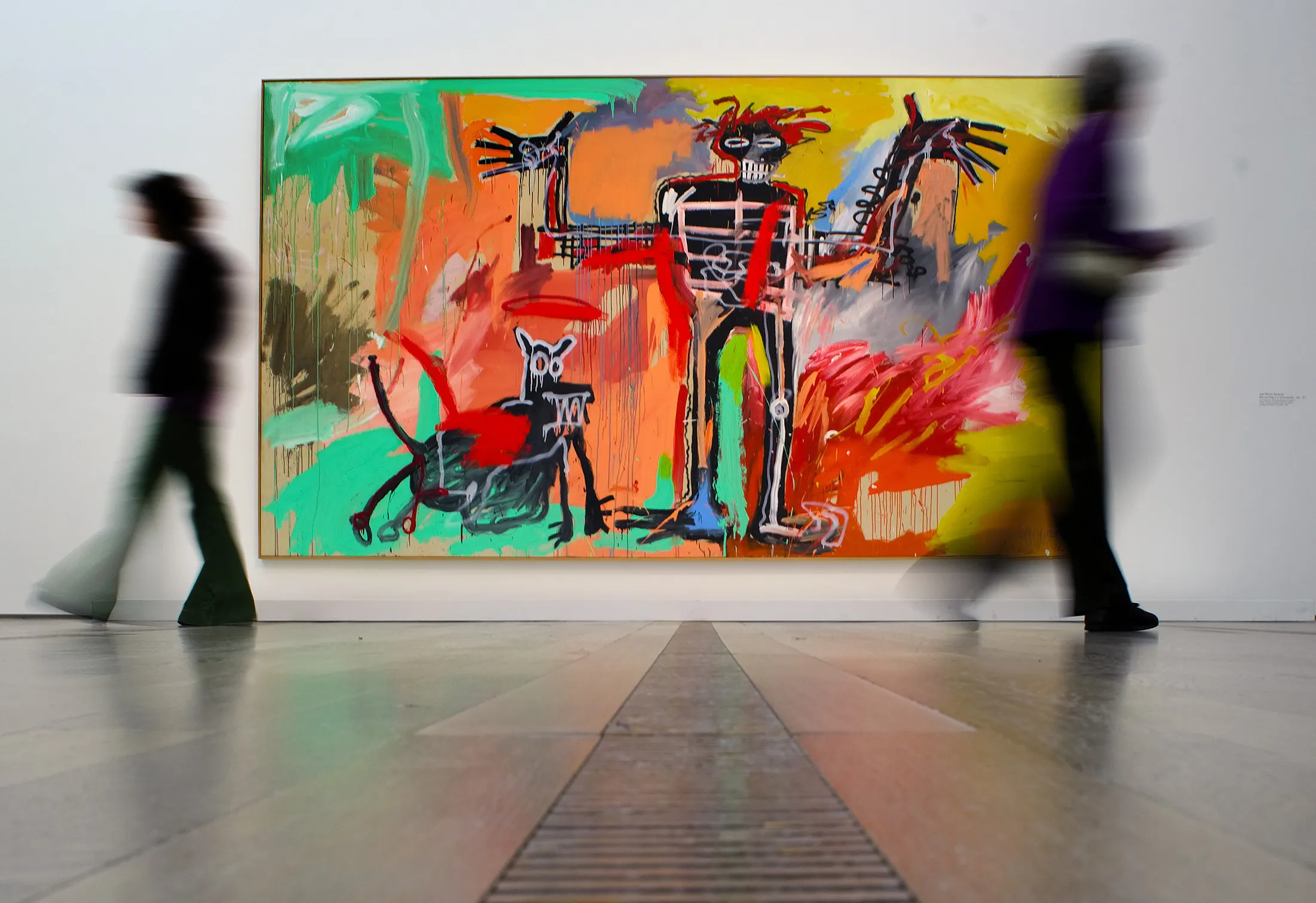 Visitors pass in front of a painting by Jean-Michel Basquiat intitled "Boy and Dog in a Johnnypump" in Basel.  
