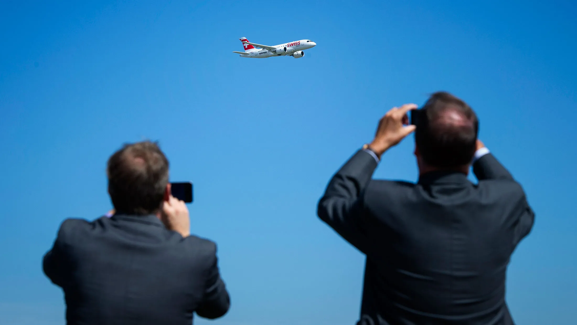 Attendees take photographs of the new Bombardier Inc. CS100 airplane during a flying demonstration at the company's facility in Toronto, Ontario, Canada, on Sept. 10, 2015.
