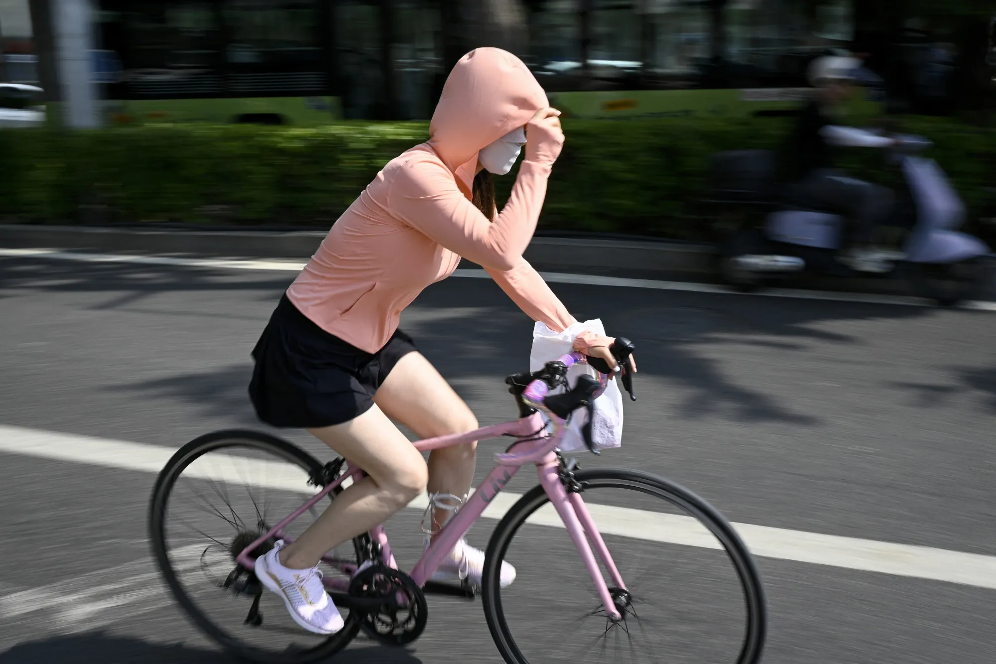 A woman wearing sun protective clothing in Beijing on June 23.