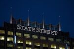 Signage for State Street Corp. is illuminated atop the State Street Financial Center building in Boston, Massachusetts.