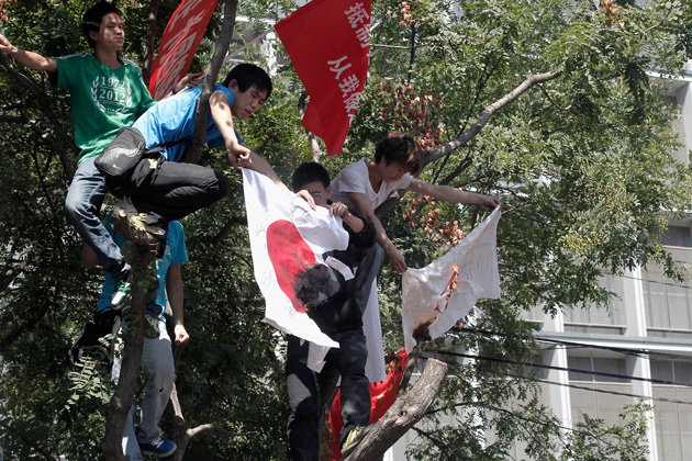 Chinese demonstrators burn a Japanese flag during an anti-Japanese protest over the disputed Diaoyu Islands, known as the Senkaku Islands in Japan, outside the Japanese Embassy on September 15, 2012 in Beijing, China