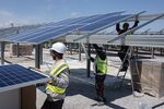 Workers install solar panels at a site in Laudun L'Ardoise, France.