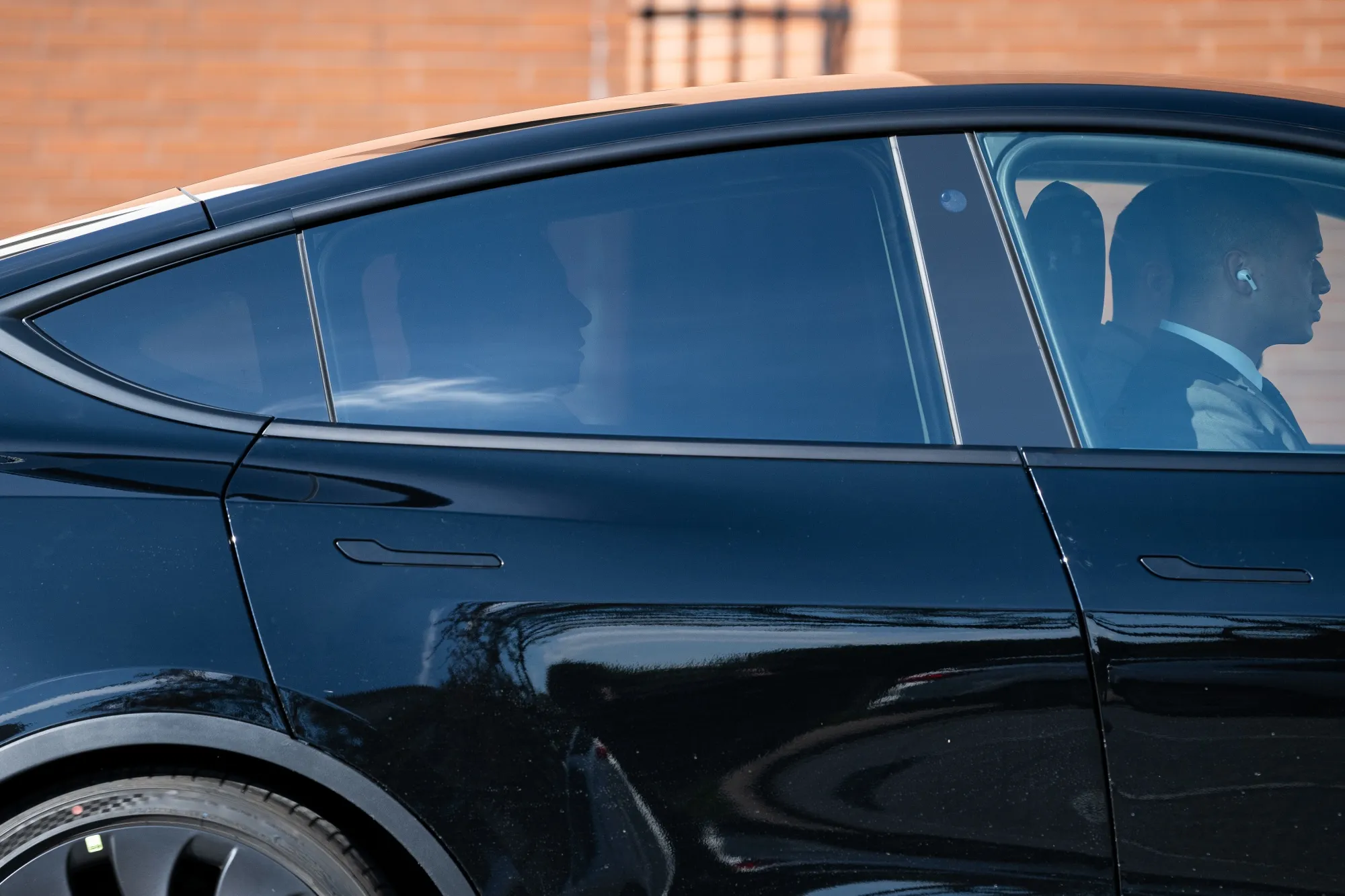 Elon Musk, left, departs from federal court in a Tesla in Wilmington, Delaware, on&nbsp;Nov. 16.