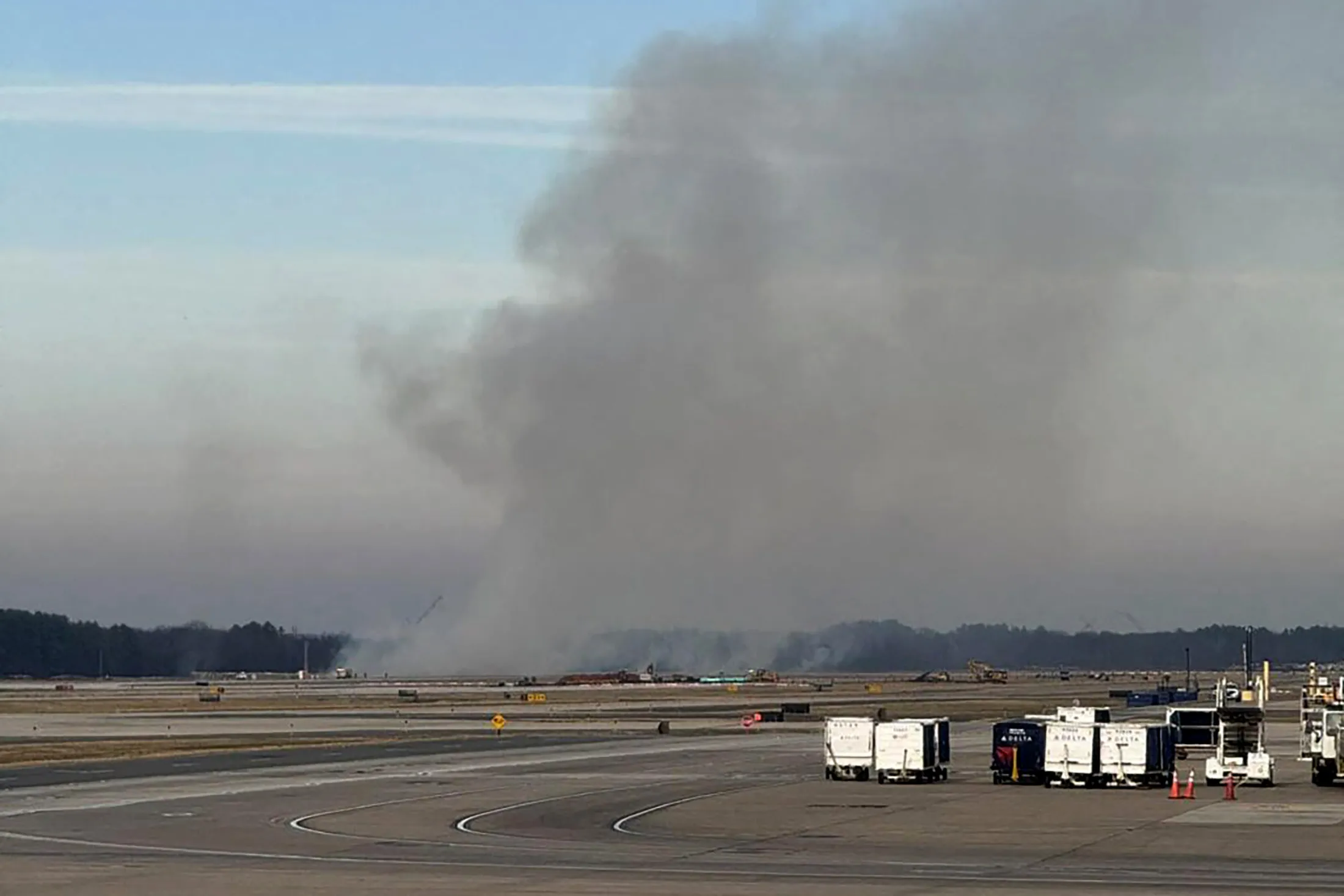 Smoke billows on a runway after a United Airlines flight returned shortly after takeoff following a reported engine fire, at Dulles International Airport on Dec. 13.