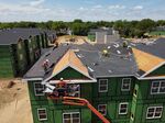 Workers roofing an apartment complex in Uniondale, New York. Many residential projects face construction delays and materials shortages, deepening the already serious gap in the U.S. low-cost housing supply. 