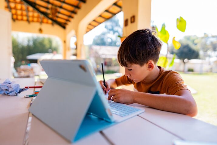 Boy studying using digital tablet at home