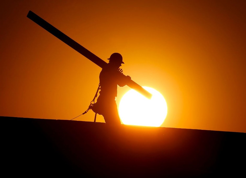 A home builder at sunrise this June in Arizona, where temperatures during a deadly heat wave hit 120 degrees.