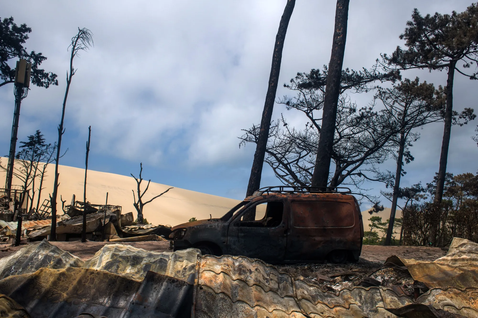 A burned out vehicle and remains of the Blue Waves campsite following wildfires in July.&nbsp;