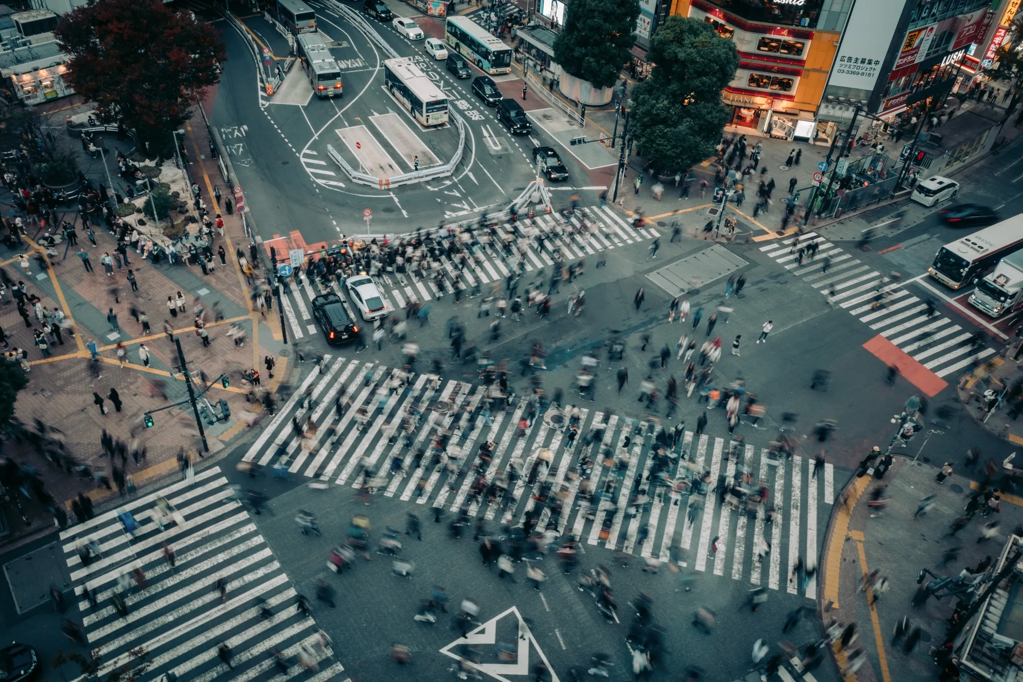 Pedestrians cross an intersection in the Shibuya district of Tokyo, Japan.