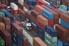 A truck travels between shipping containers stacked at Kwai Tsing Container Port Terminal 4, operated by Hongkong International Terminals Ltd., in Hong Kong, China, on Friday, June 28, 2013. Hong Kong’s May export numbers contracted by 1% year-on-year, the city’s government said, against an estimated gain of 3.4% from a survey of 11 economists.