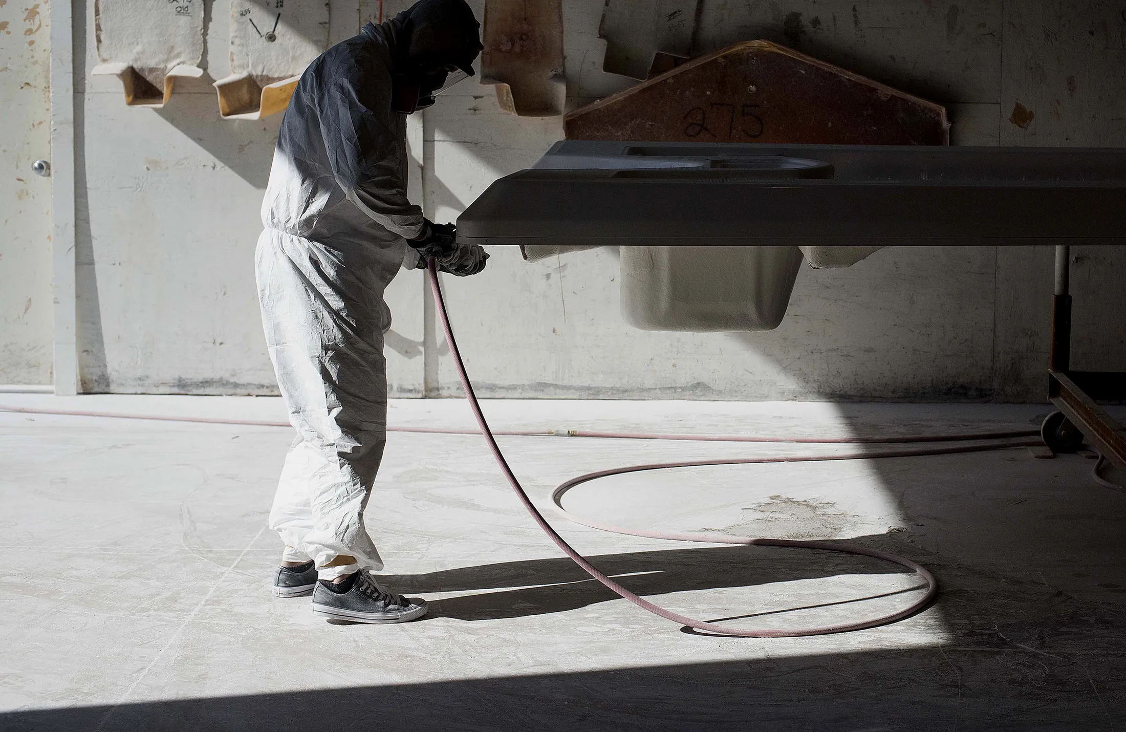 An employee sands the hull of a boat at a manufacturing facility in Edgewater, Florida.
