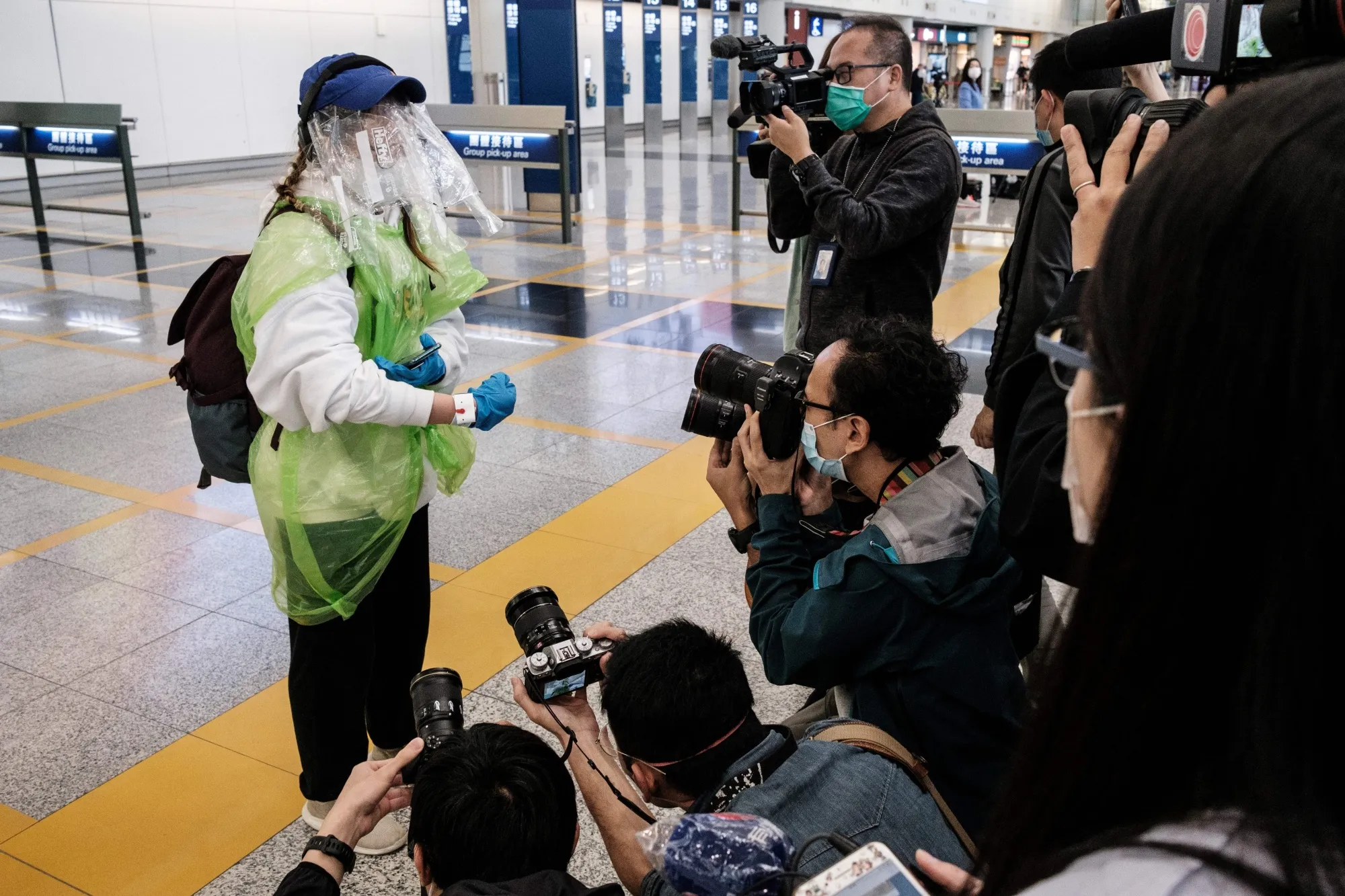 A passenger shows her quarantine tracking wristband at Hong Kong International Airport on March 19.