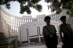 Guards stand outside the People's Bank of China in Beijing, China.
