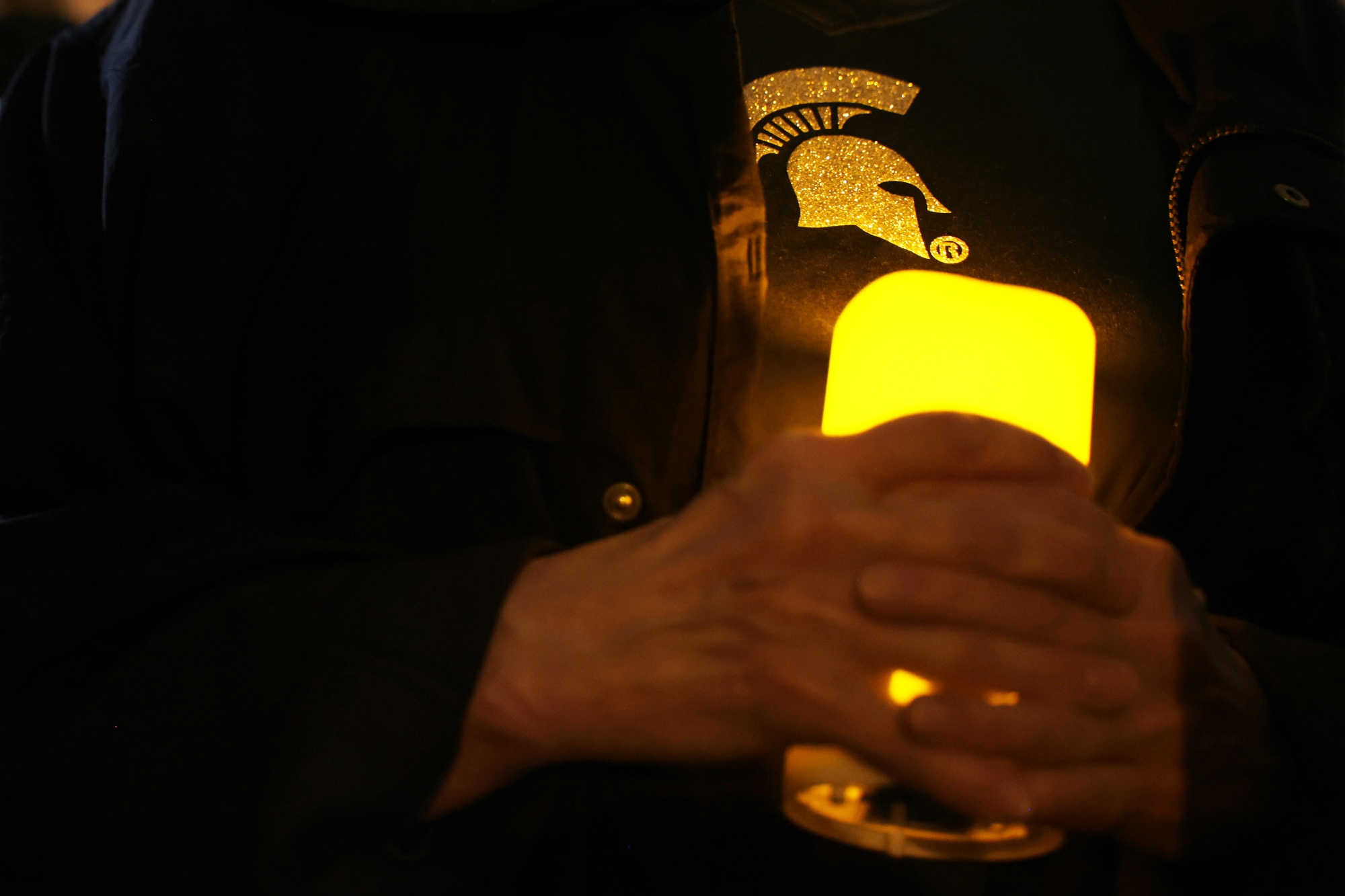 A woman holds a candle during a candlelight vigil to remember victims of a shooting at Michigan State University on Feb. 16.