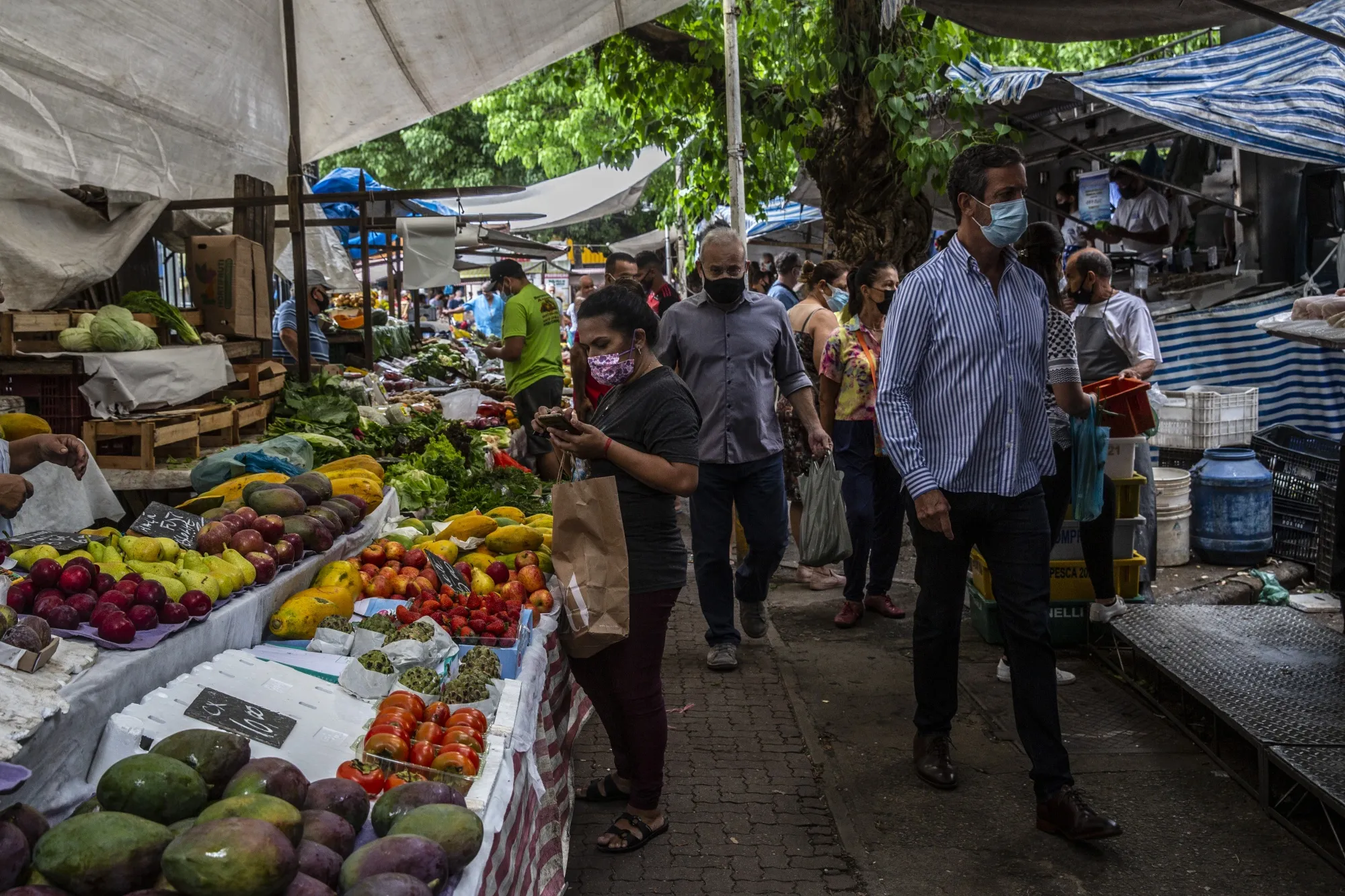 Shoppers browse stalls of fresh fruits and vegetables at a street market in the Ipanema neighborhood Rio de Janeiro, Brazil.