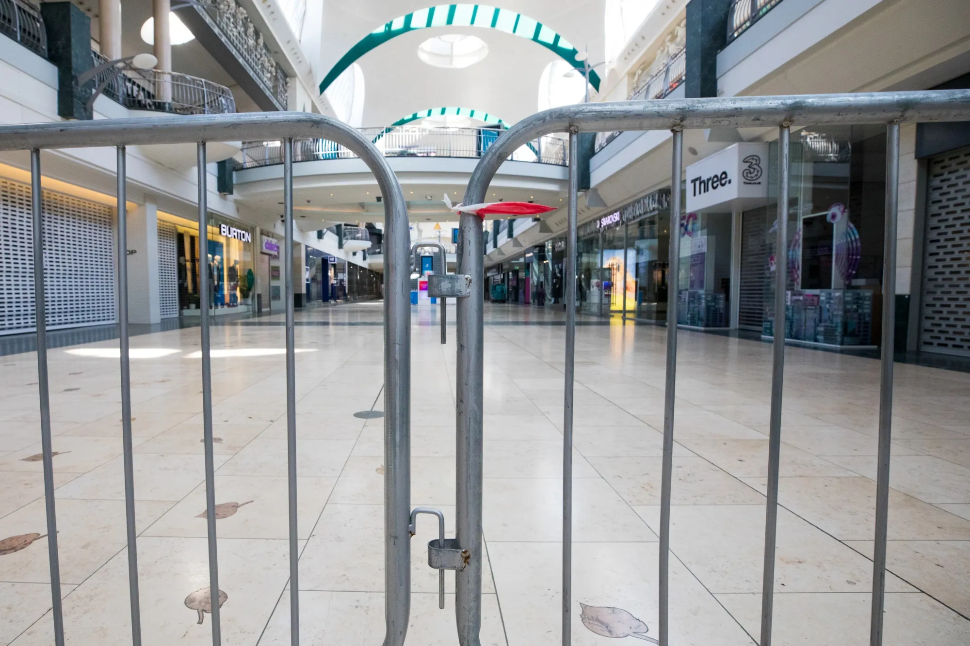 Stores sit closed beyond a barrier inside the Bluewater shopping centre,&nbsp;near Dartford, U.K.