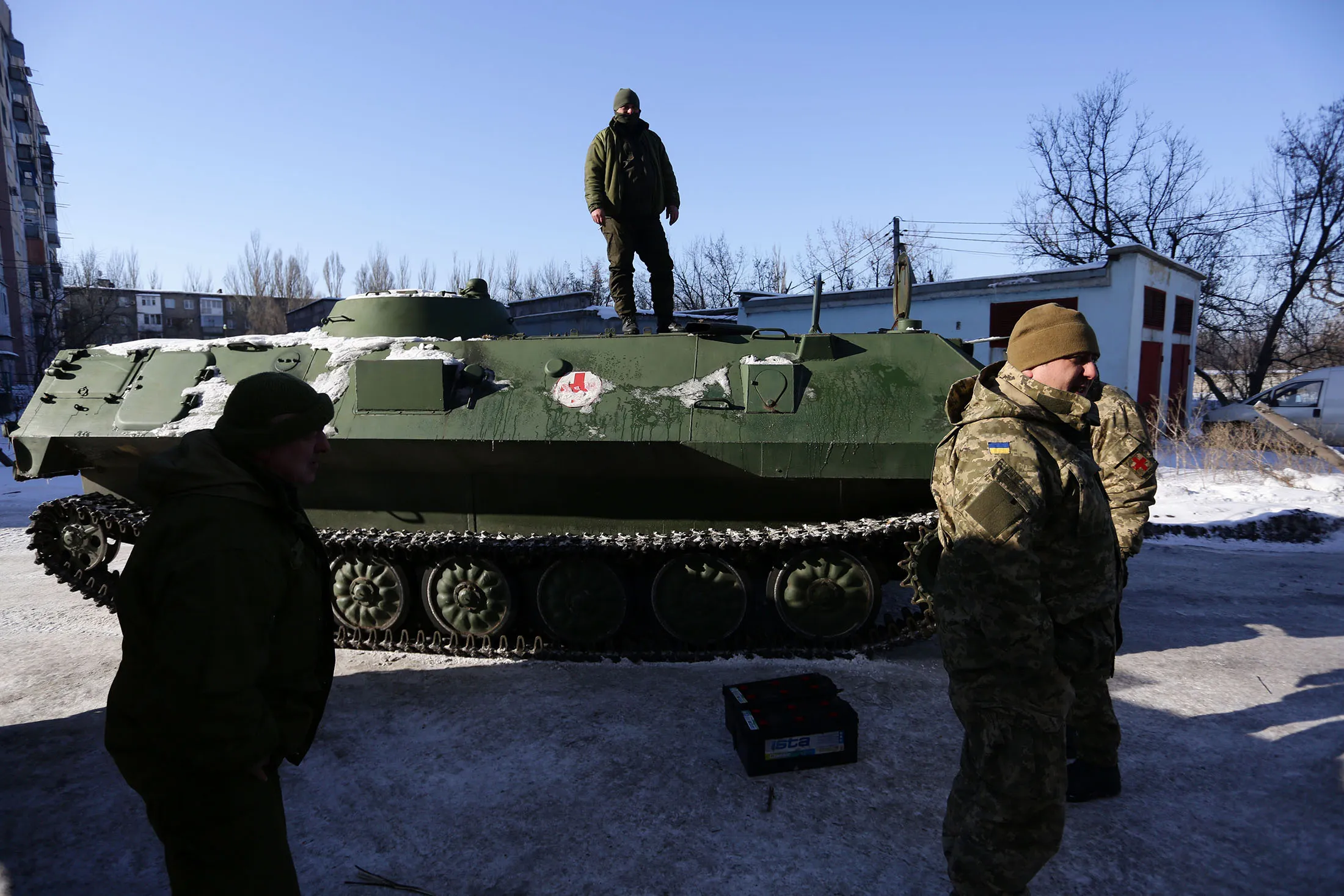 Ukrainian medical servicemen stand on an Armoured Personnel Carriers (APC) after they carried wounded servicemen to hospital in Ukraine-controlled town of Avdiivka, in Donetsk region on January 30, 2017. A sudden surge in clashes between Ukrainian forces and Russian-backed rebels killed at least six people on January 30, 2017 despite a supposed truce in Ukraine's war-scarred east. The overall death toll for the past two days rose to 11 after the bloodiest outburst of violence since the former Soviet republic and its foes agreed an 'indefinite' ceasefire last month. The violence coincided with a visit by Ukrainian Petro Poroshenko to Berlin at which he urgend German Chancellor Angela Merket to step up economic sanctions on Russia for its interference in his ex-Soviet State. / AFP / Aleksey FILIPPOV (Photo credit should read ALEKSEY FILIPPOV/AFP/Getty Images)
