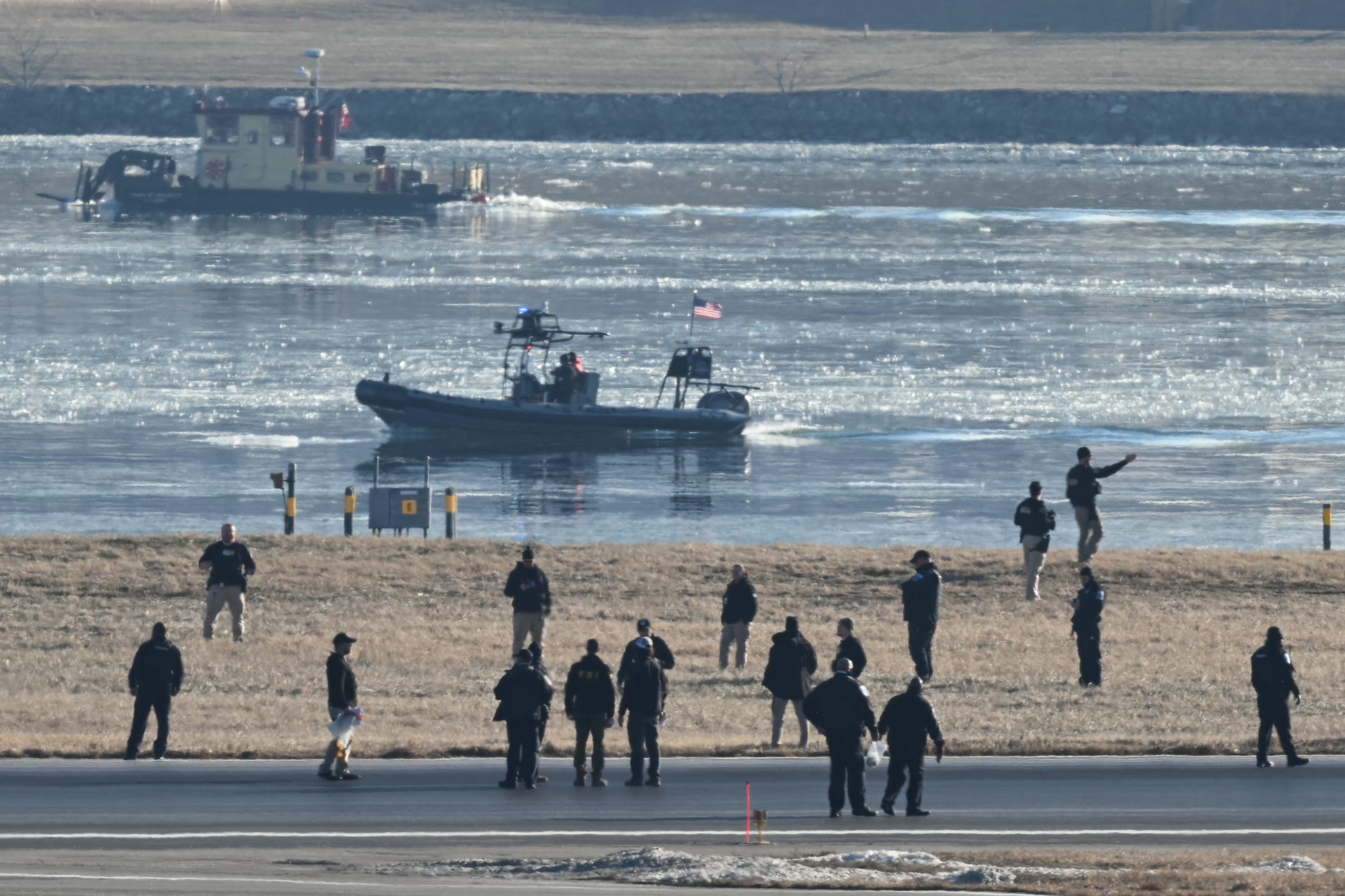 Law enforcement agents on a runway at Ronald Reagan Washington National Airport as rescue crews search the waters of the Potomac River near Washington, DC, on Jan. 30.&nbsp;