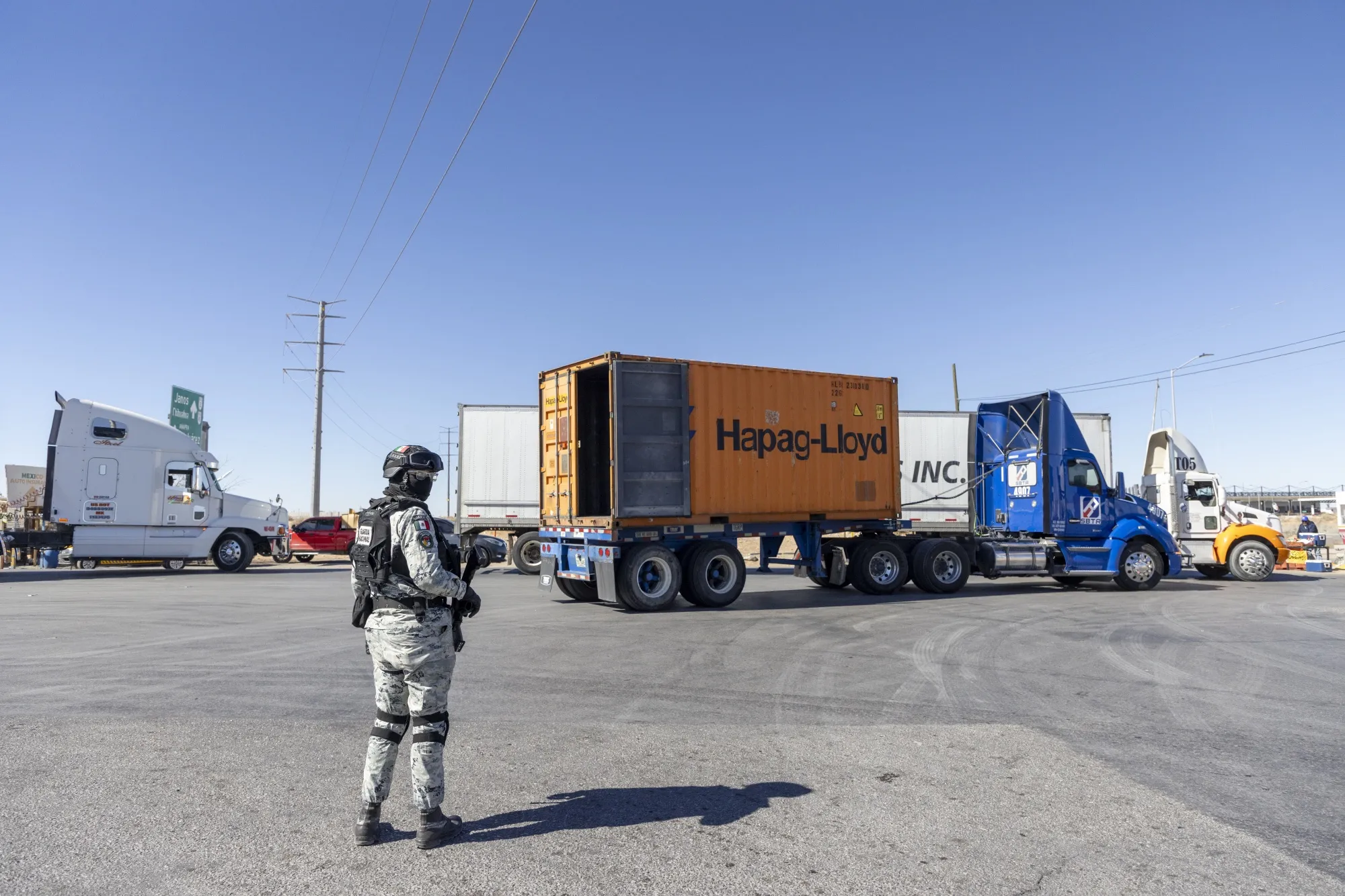 Miembros de la Guardia Nacional Mexicana inspeccionan camiones que viajan a través de la frontera en Ciudad Juárez, México.