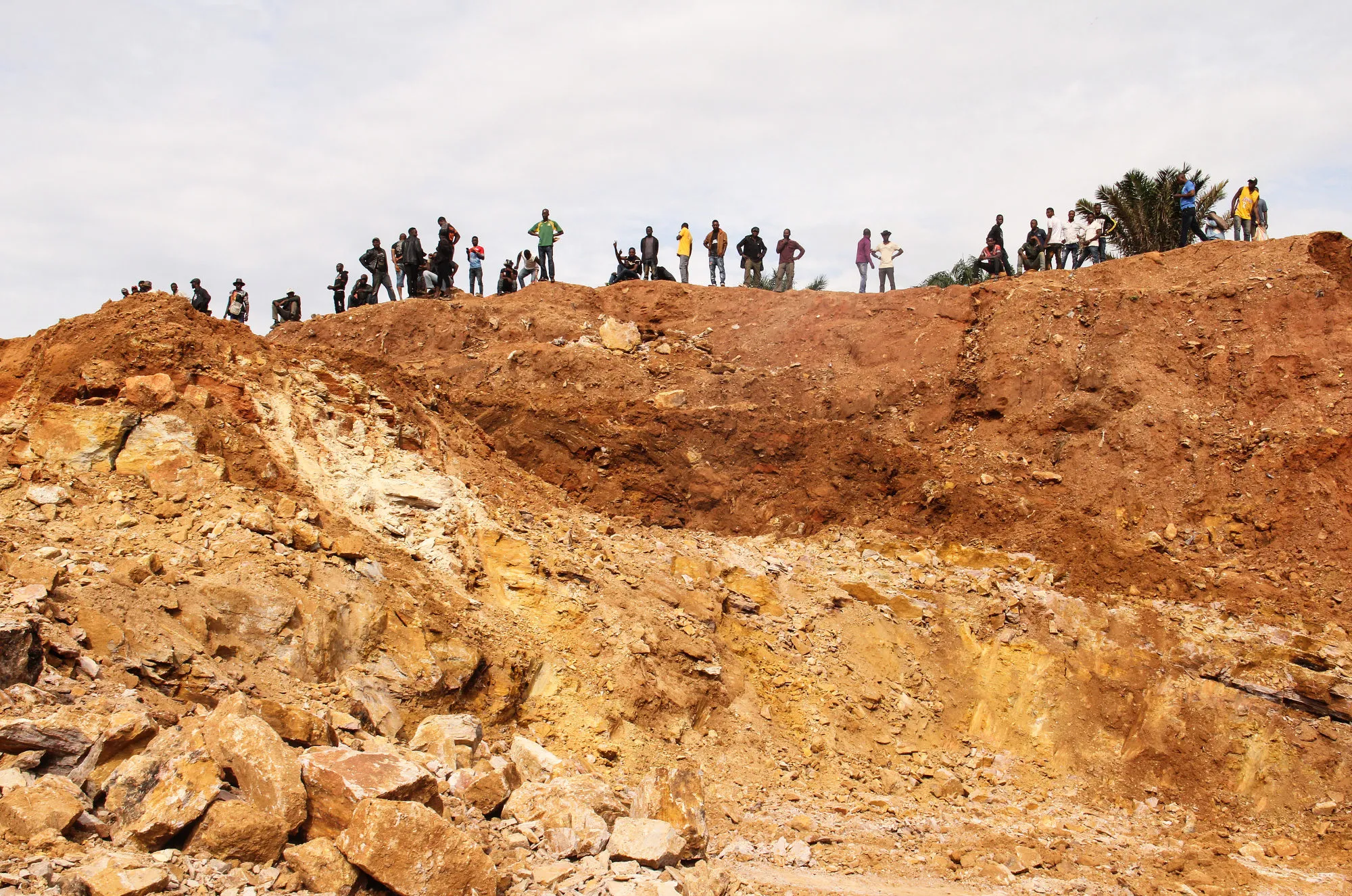 Artisanal miners stand as they wait for safety equipment to arrive and permission to start extracting cobalt&nbsp;by a freshly excavated pit in Kolwezi, Democratic Republic of the Congo.