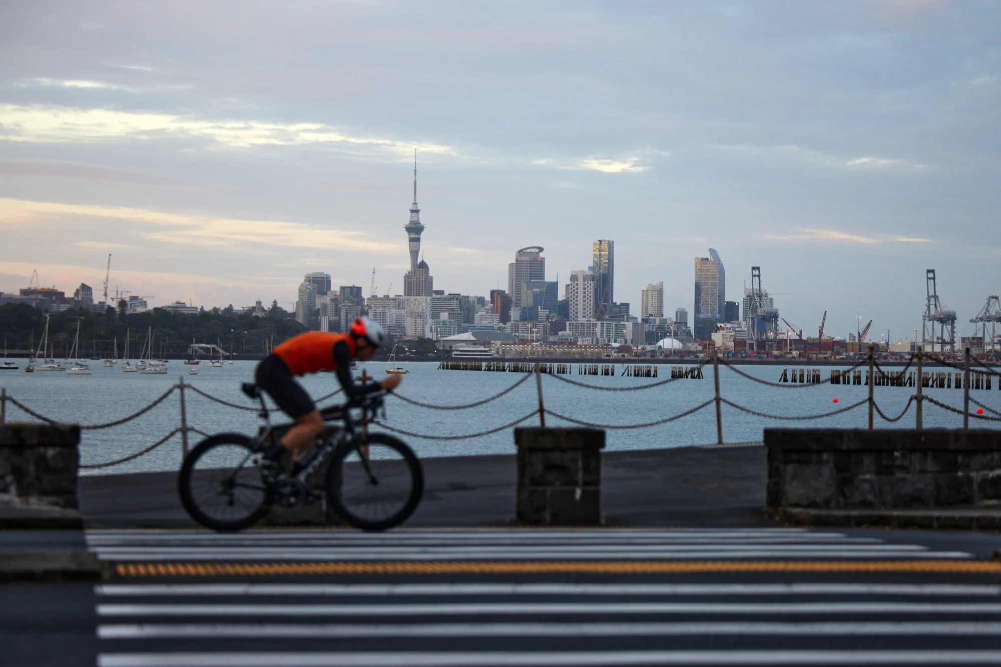 A cyclist rides past the city's skyline in Auckland, New Zealand.