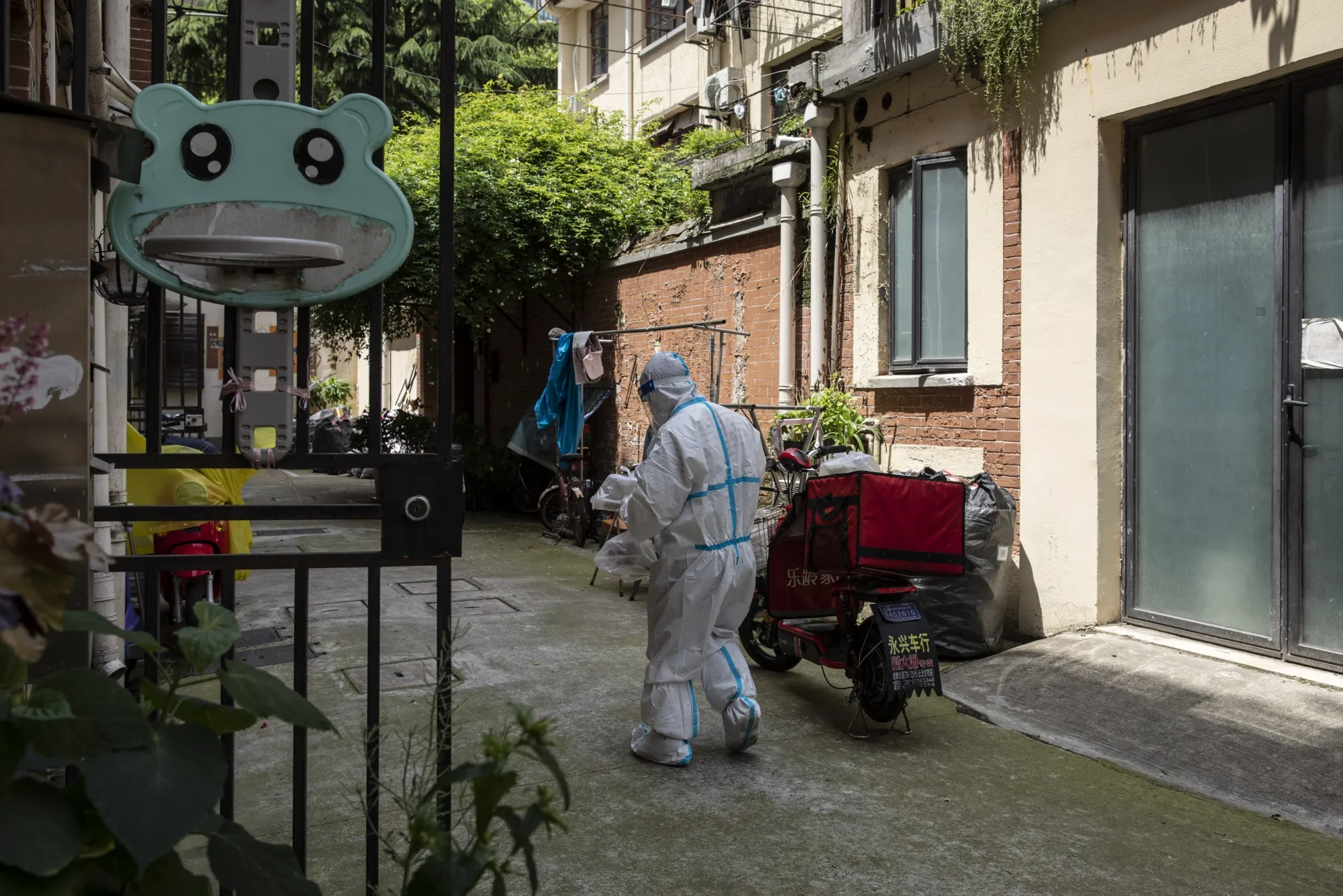 A volunteer in personal protective equipment delivers food packages during a lockdown in Shanghai, China, on April 28.