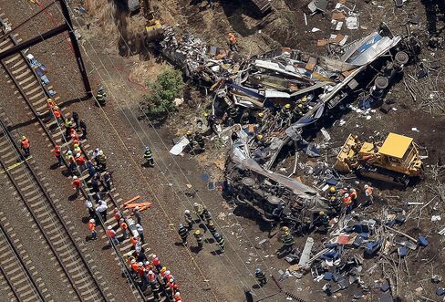 Investigators and first responders work near the wreckage of the crash on May 13, 2015 in north Philadelphia, Pennsylvania.