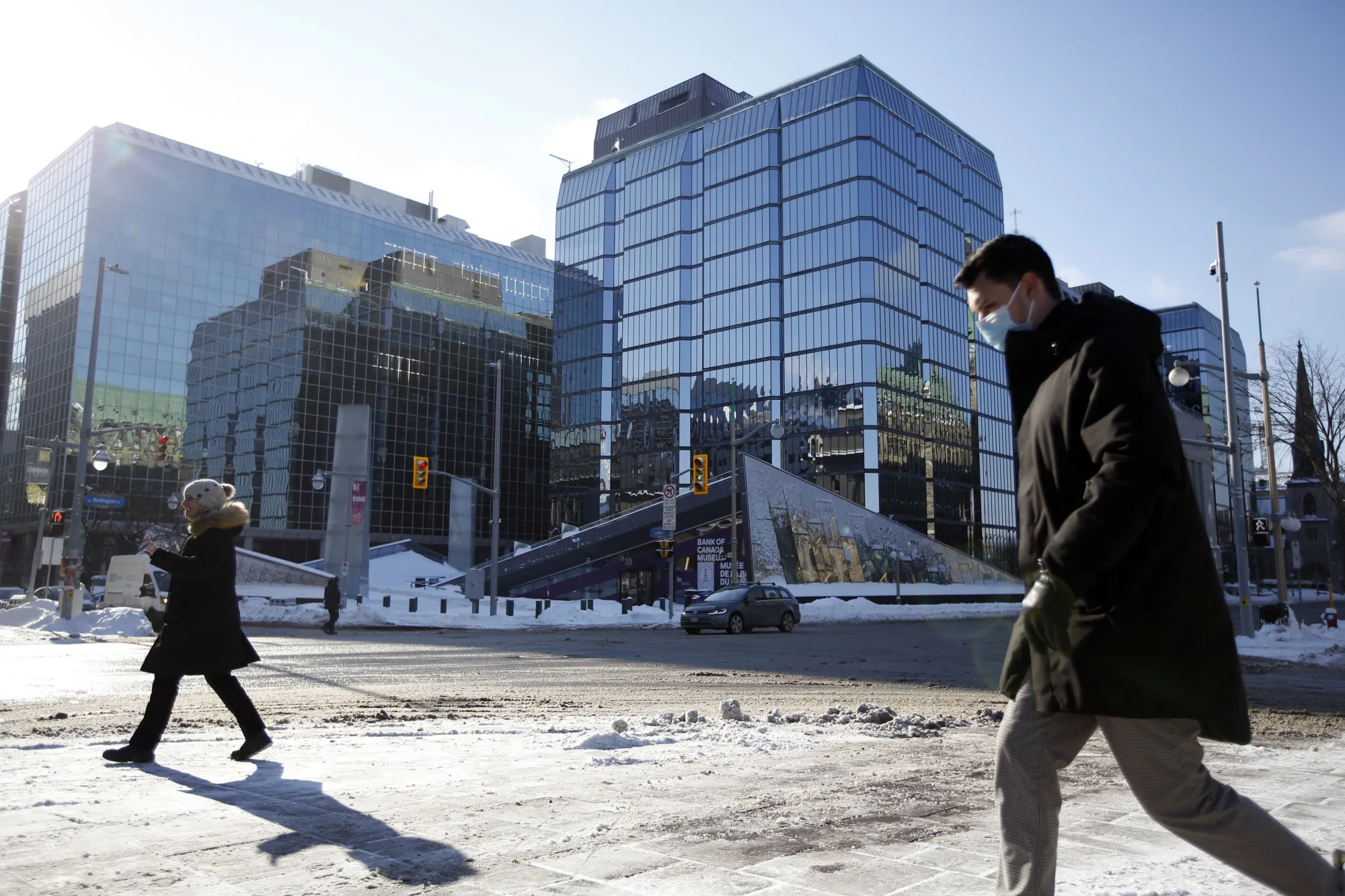 Pedestrians pass the Bank of Canada building in Ottawa on Jan. 25, 2022.
