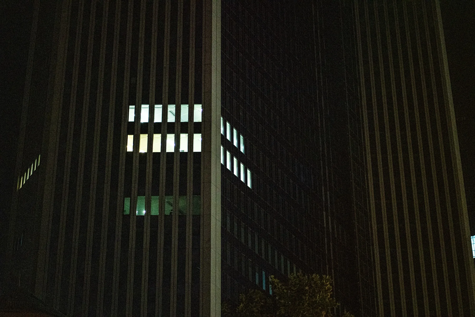 A partially lit commercial building at night in Frankfurt.