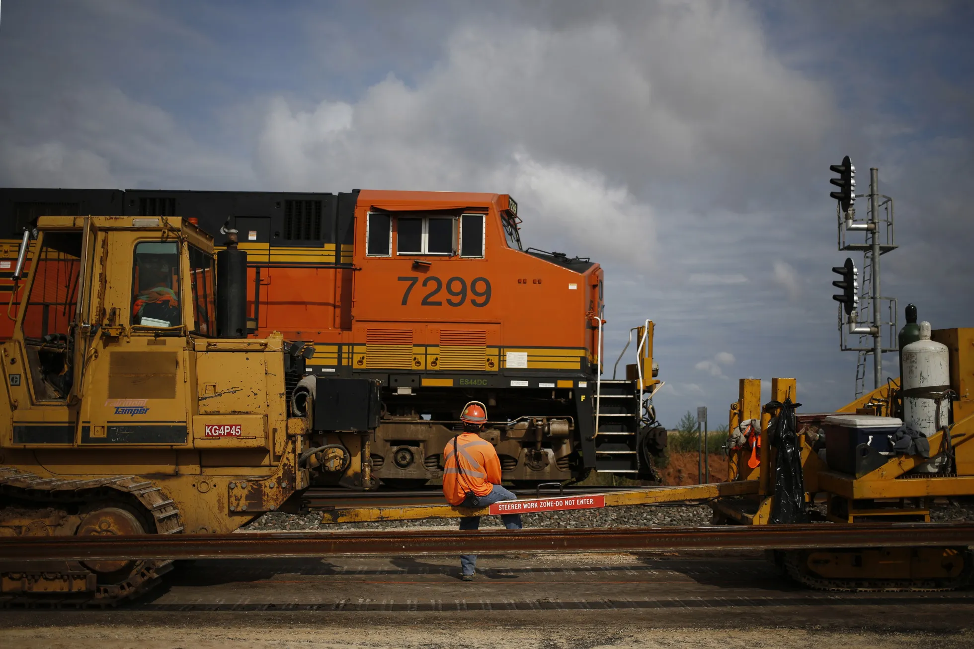 A maintenance worker watches as a train passes in Alva, Oklahoma.
