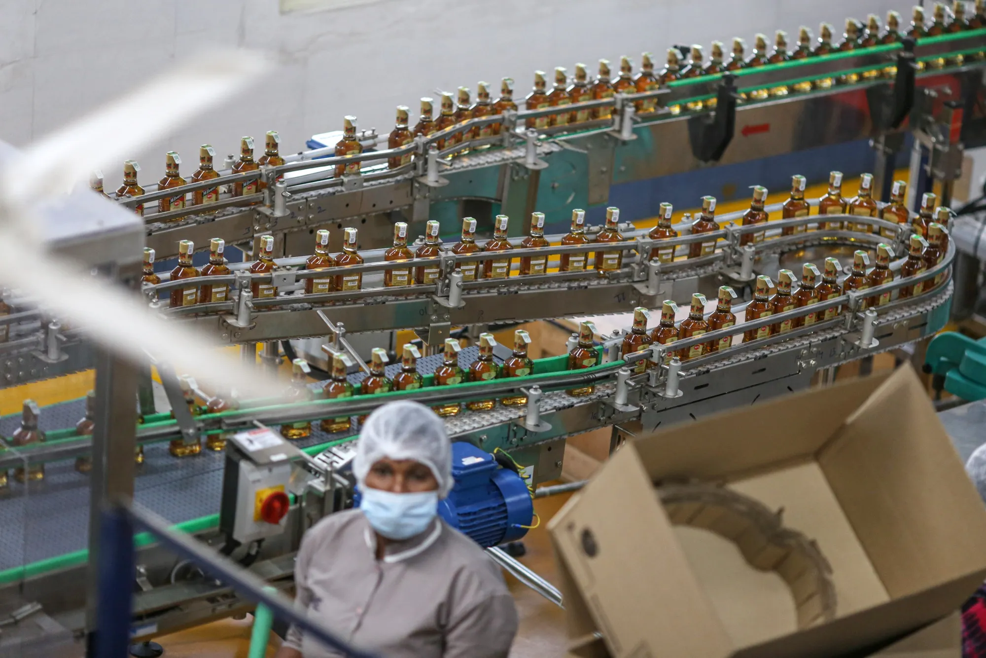 Whiskey bottles travel on conveyor belts inside a bottling plant of Diageo Plc., in Bengaluru, India, on Aug. 25, 2022.&nbsp;