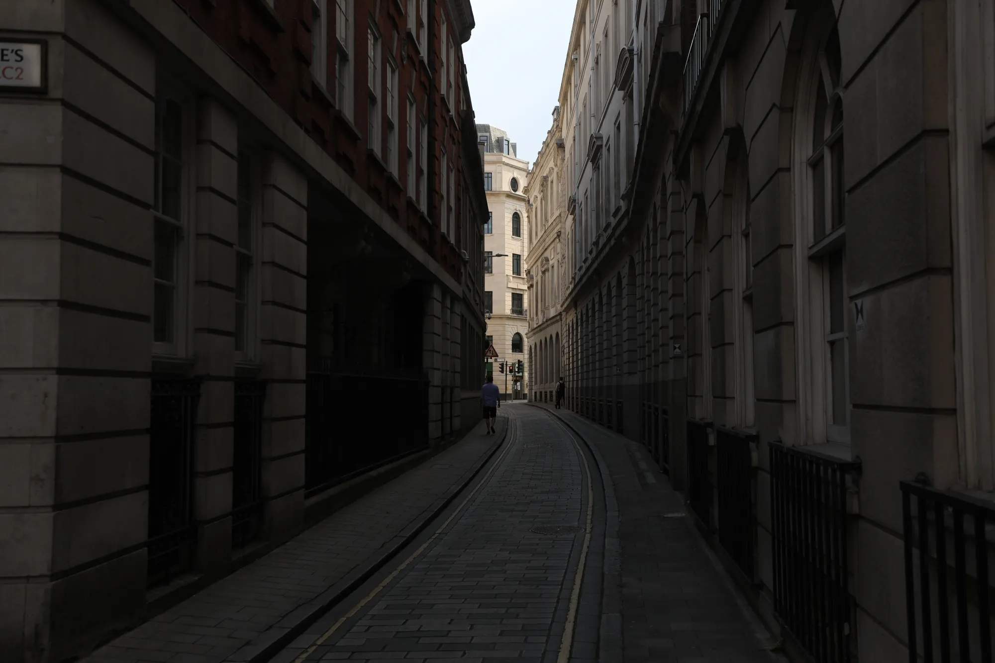 A solitary pedestrian passes along a passageway in the City of London in London, on Aug. 12.