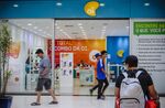 Pedestrians pass in front of an Oi SA store in Brasilia, Brazil.