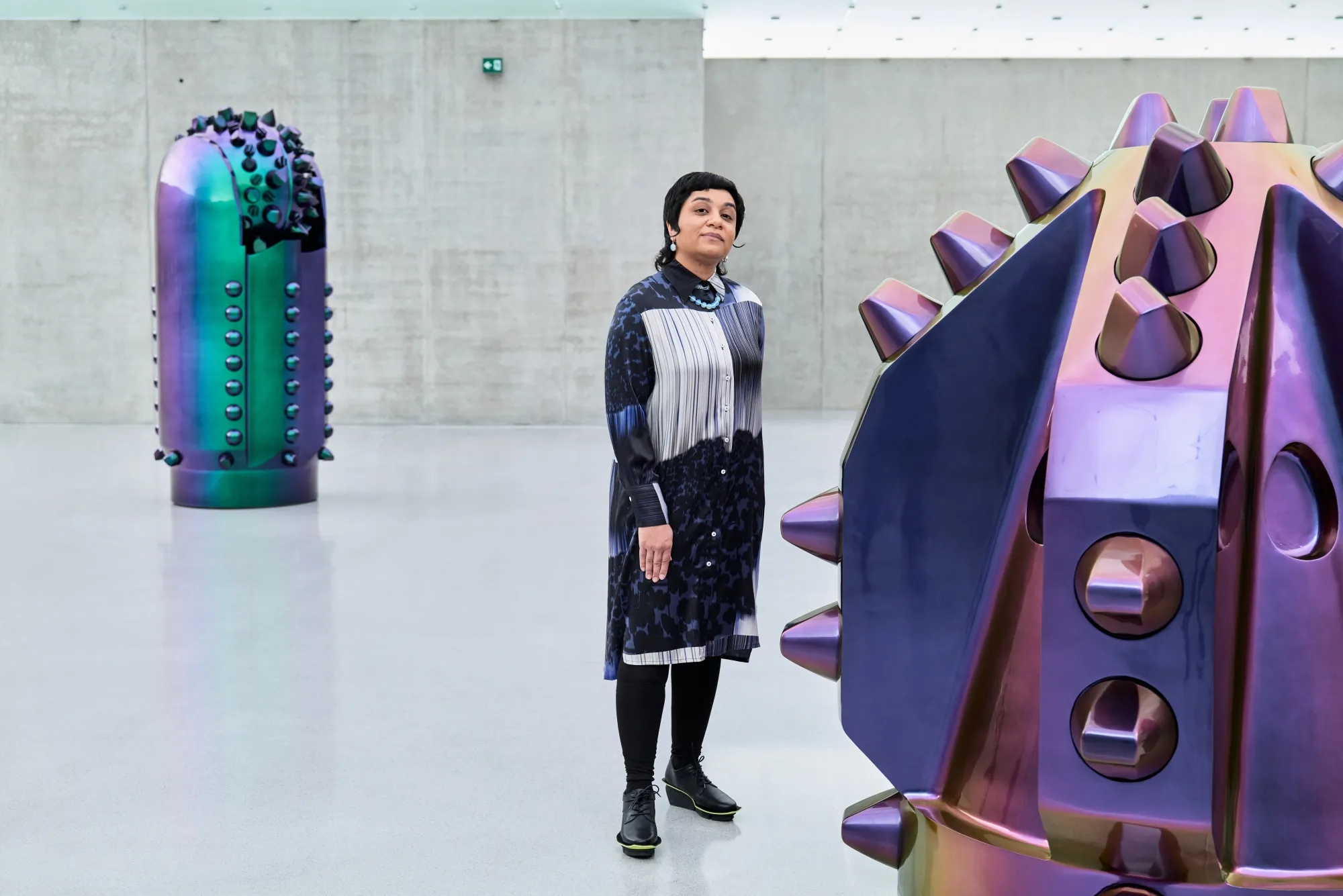 Kuwaiti artist Monira Al Qadiri stands with her works titled Alien Technology, which are made up of sculptures depicting&nbsp;enlarged oil drill bits in iridescent colors.