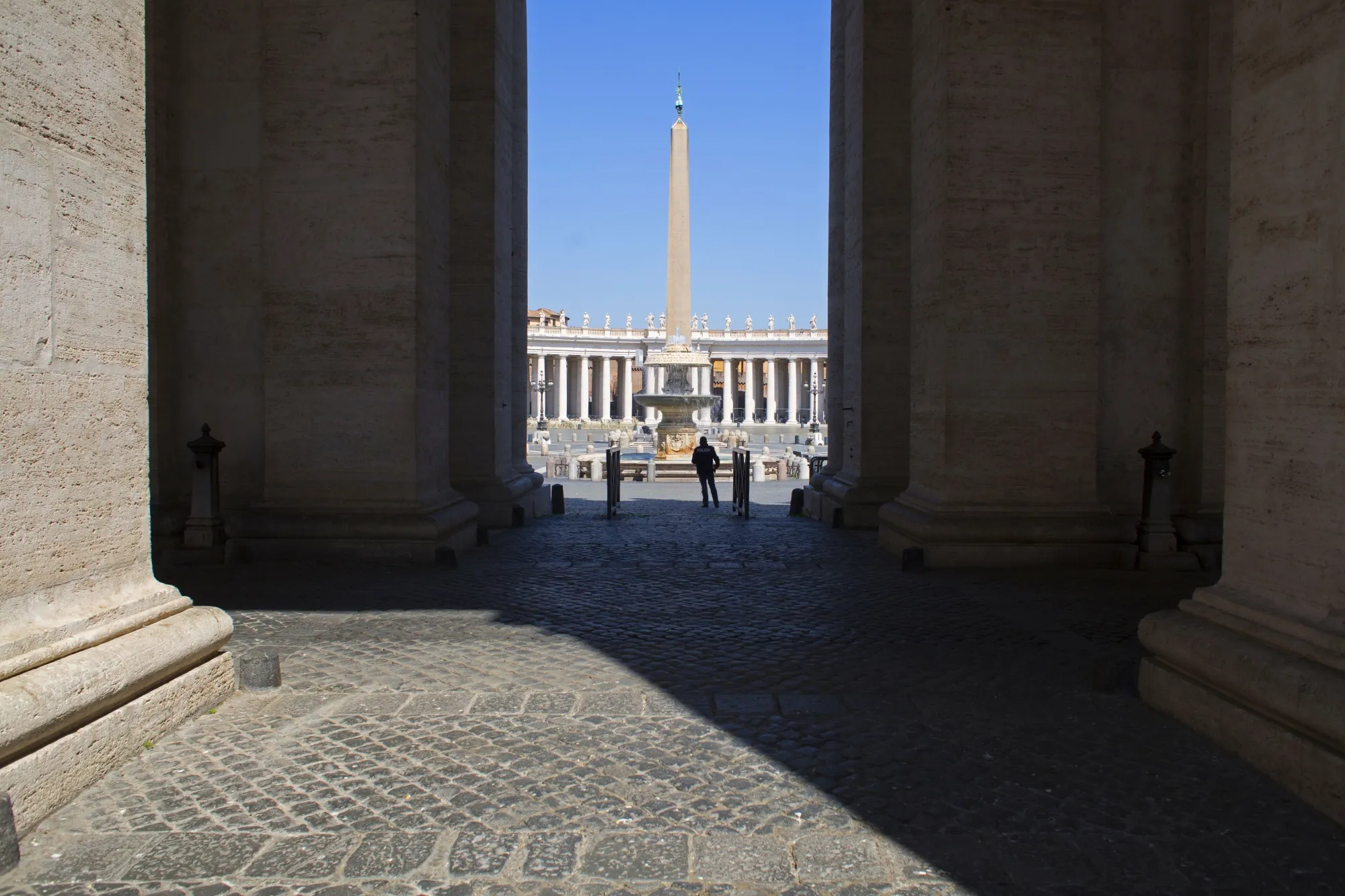 A man stands in the shadow of St. Peter's Basilica colonnade in the Vatican City during coronavirus lockdown in Rome on April 11.