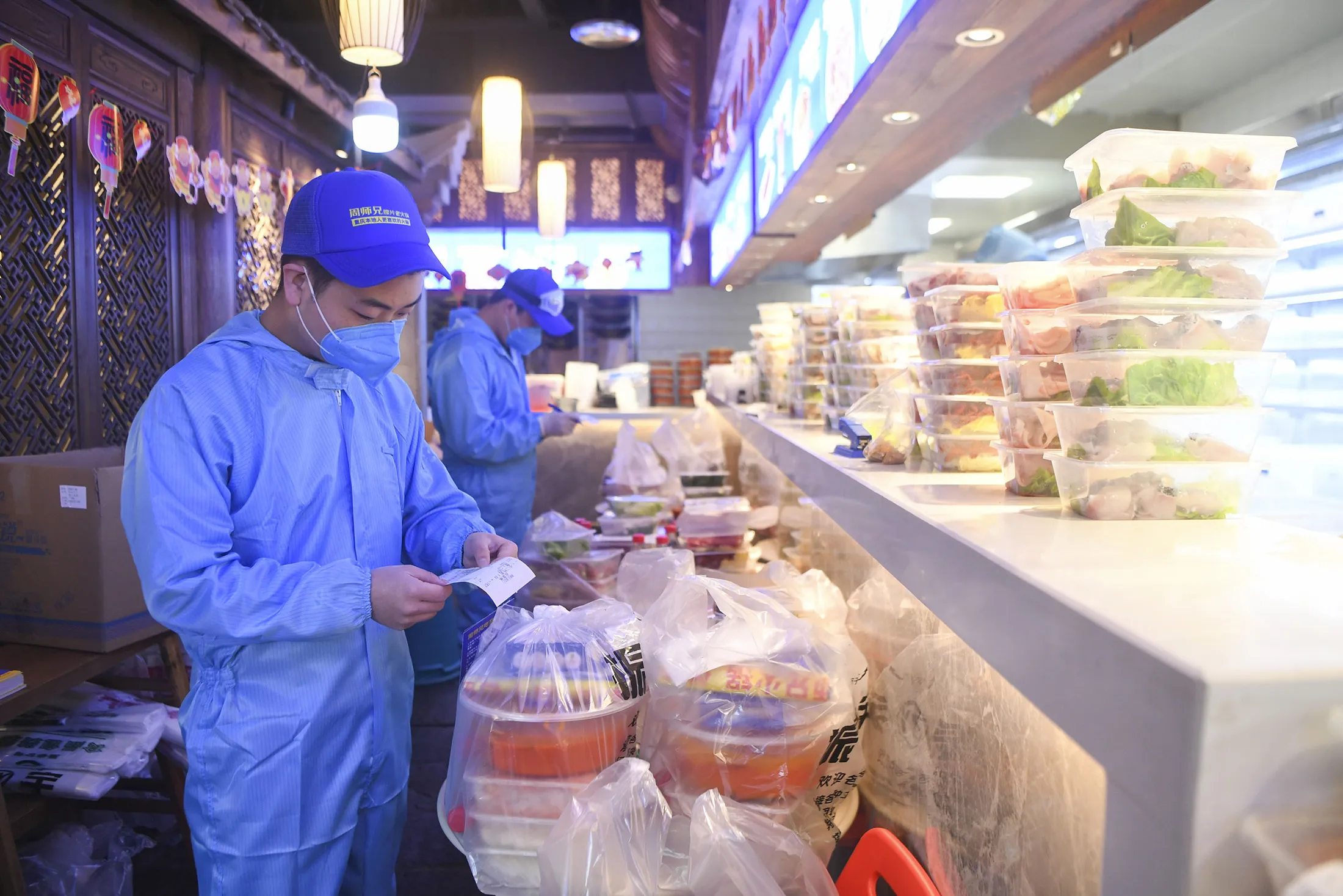 A hot pot restaurant employee checks a hot-pot takeout order in southwest China’s Chongqing Municipality on Feb. 15.