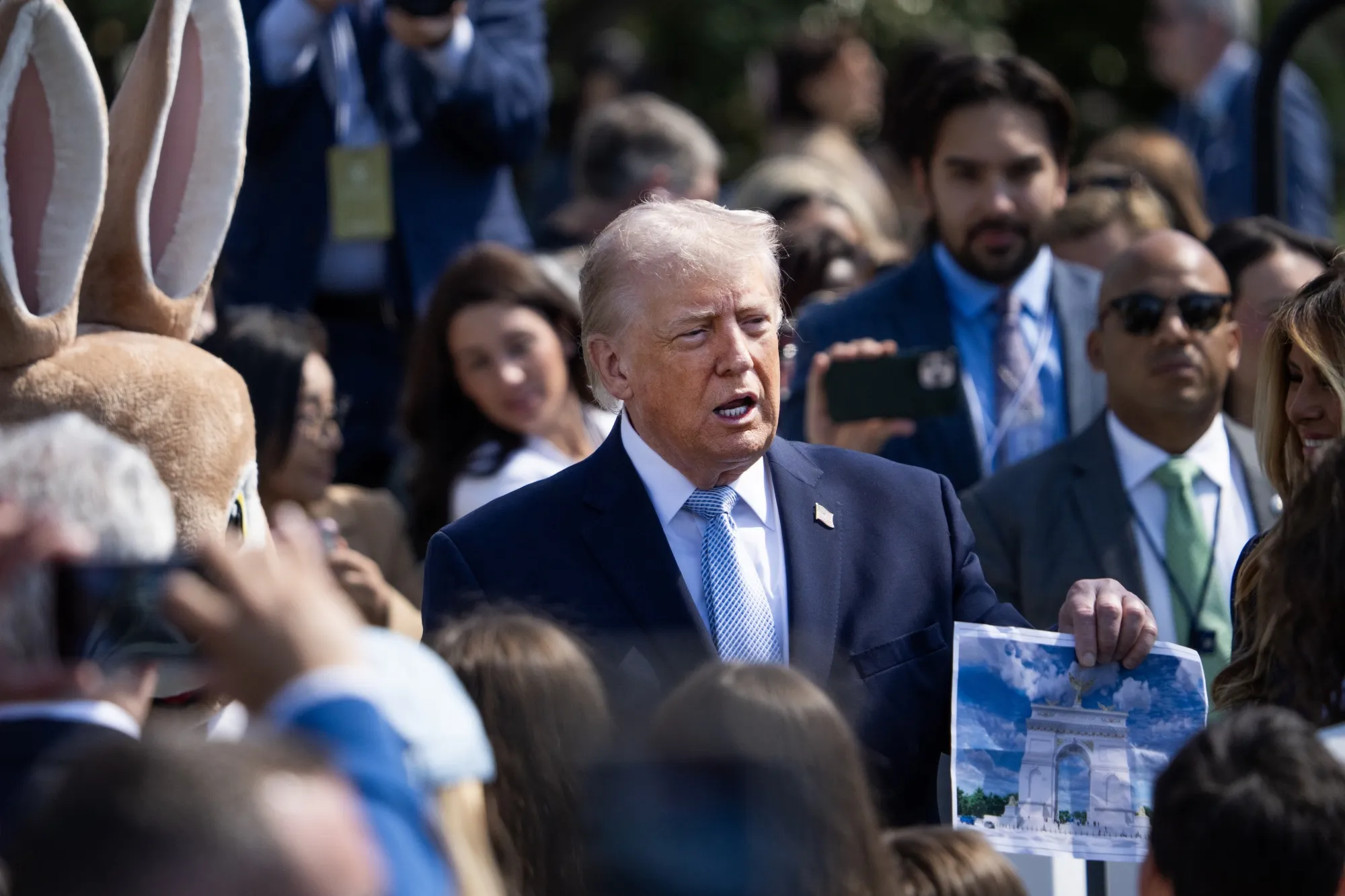 President Donald Trump holds a picture of the proposed arch on the South Lawn during the White House Easter Egg Roll on April 6