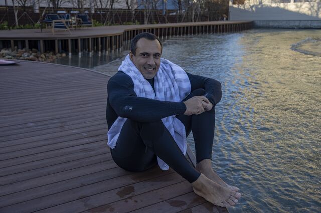 A portrait of  Sao Paulo Surf Club member Neif Salim Neto sitting on the floor near the surf pool.