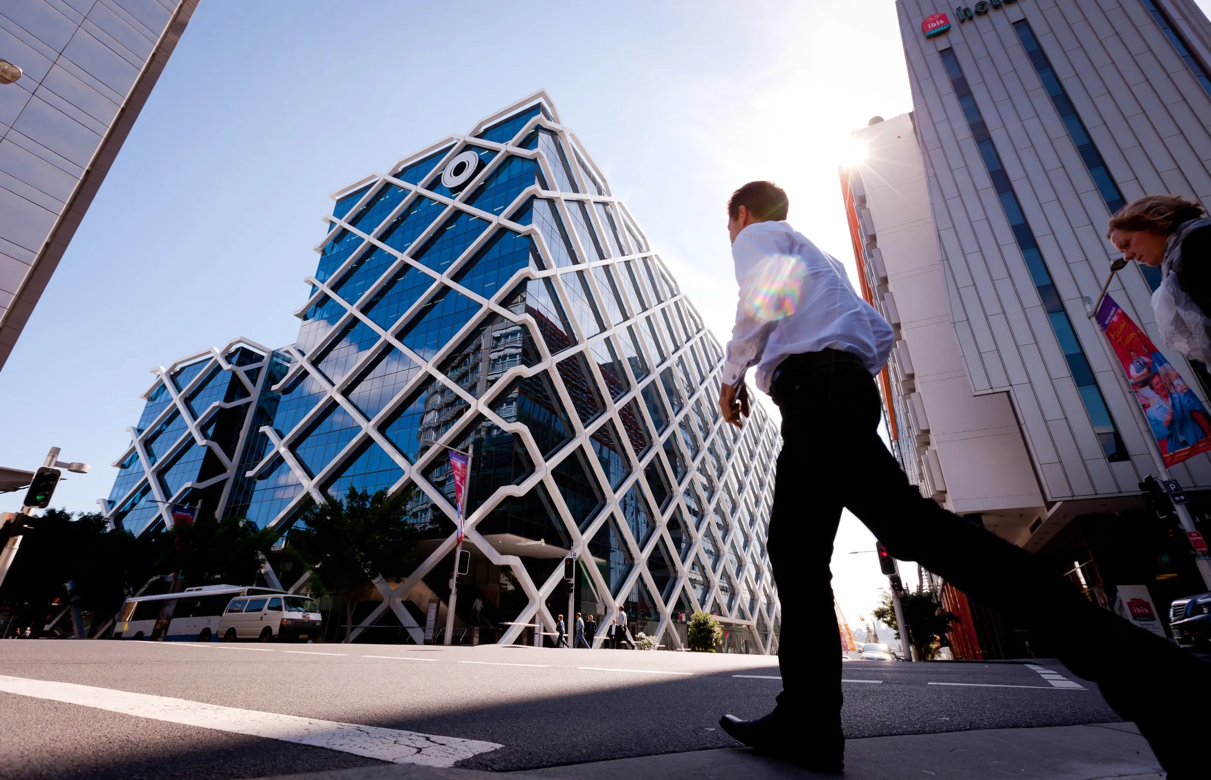 Pedestrians cross the road in front of the Macquarie Group Building in Sydney, Australia, on Friday, April 27, 2012.