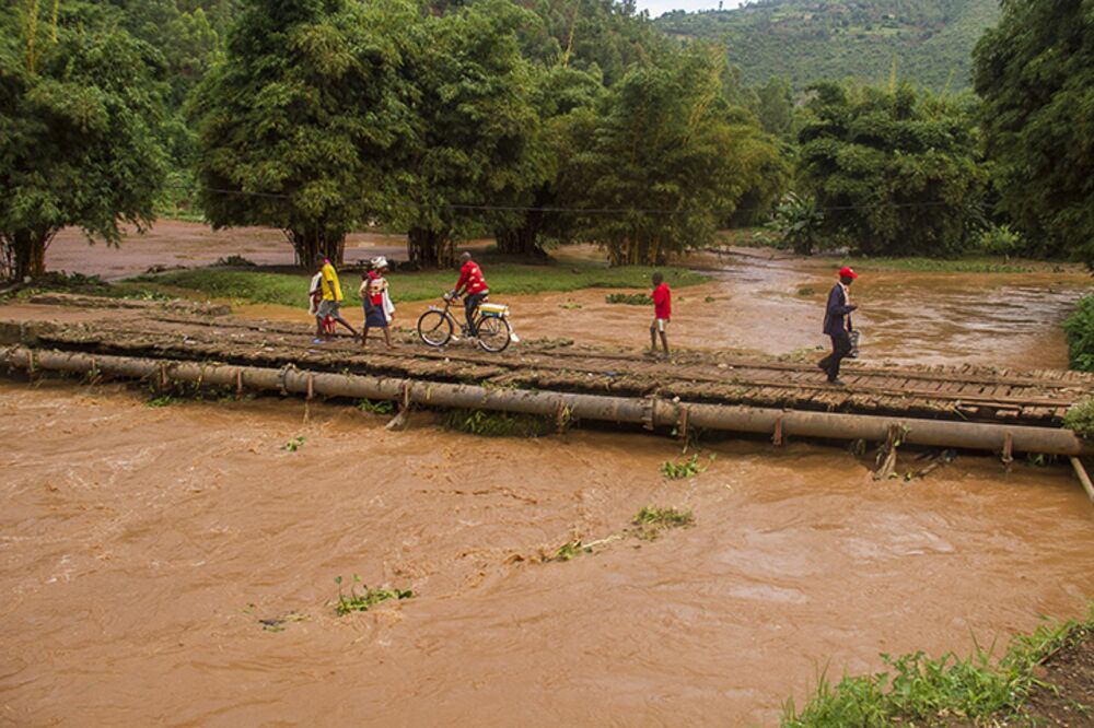 People cross a swollen river after heavy rains in Kigali.