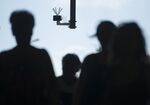 Passersby walk under a surveillance camera that is part of a facial recognition technology test at Berlin Suedkreuz station in Berlin, Germany.